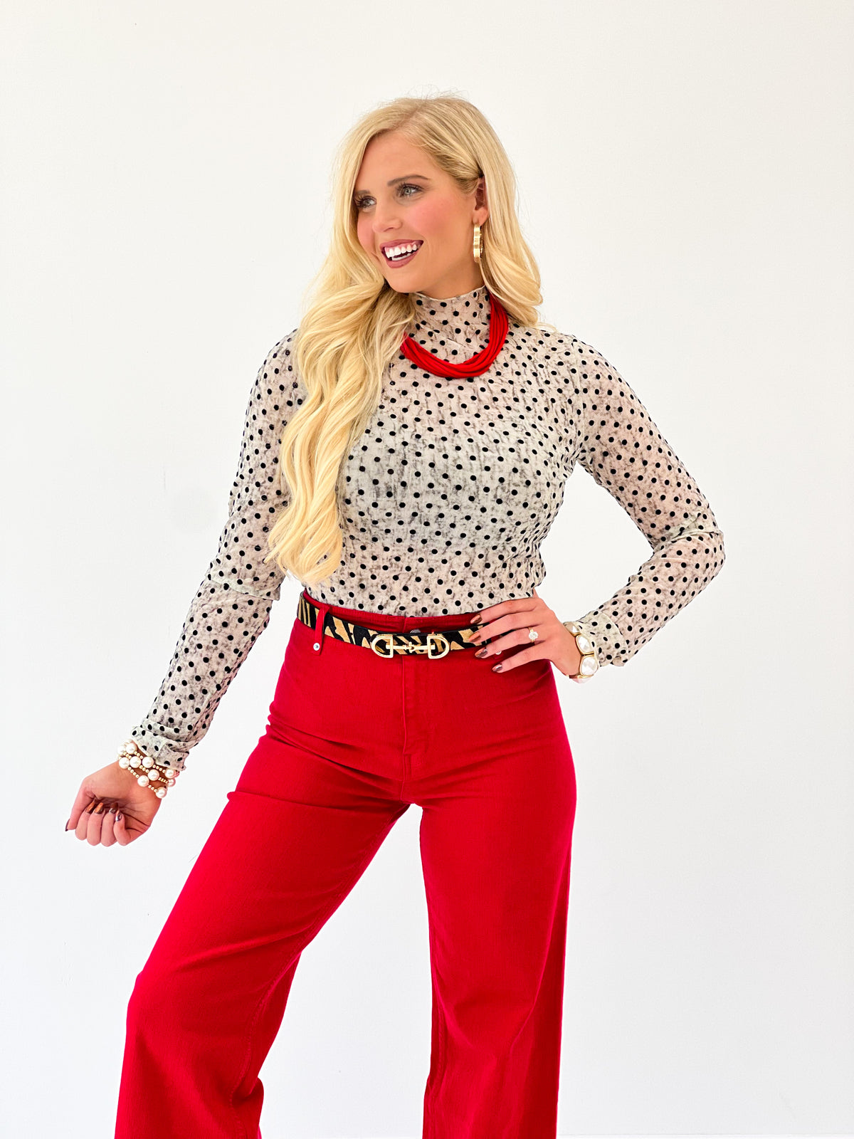 Cream polka dot mock-neck long-sleeve top, allover small black dots.