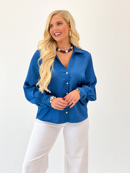 Blue satin button-up V-neck top with long sleeves and front buttons