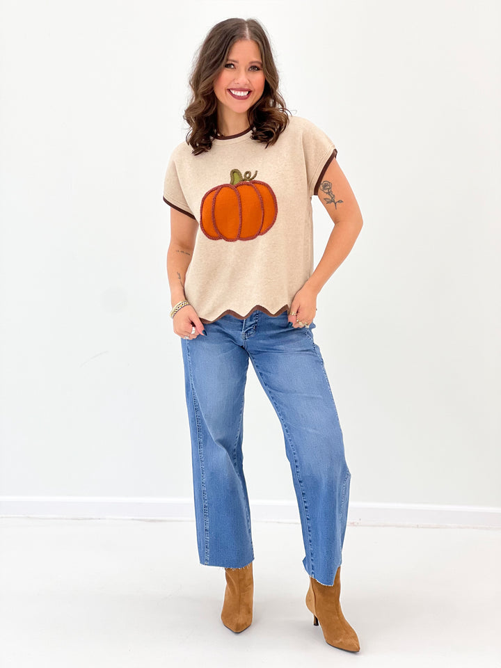 Light taupe scallop-hem sweater top with short sleeves and pumpkin graphic
