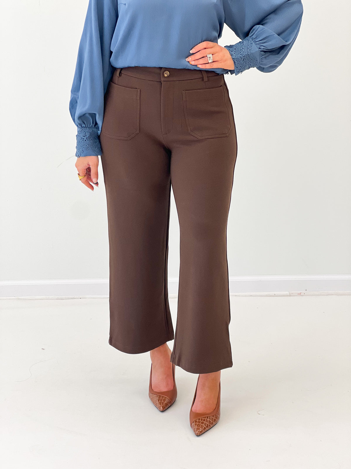 Brown straight-leg trousers with front button and patch pockets, tailored double-knit look