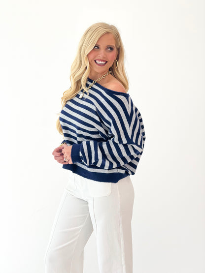Navy and white striped off-shoulder sweater with wide neckline and long sleeves