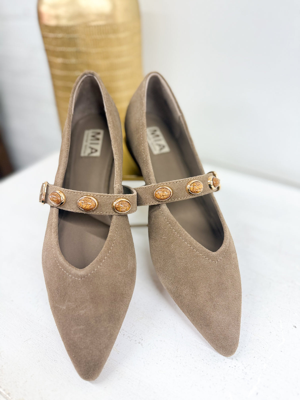 Taupe suede pointed stud flats with gold coin-stud strap and buckle