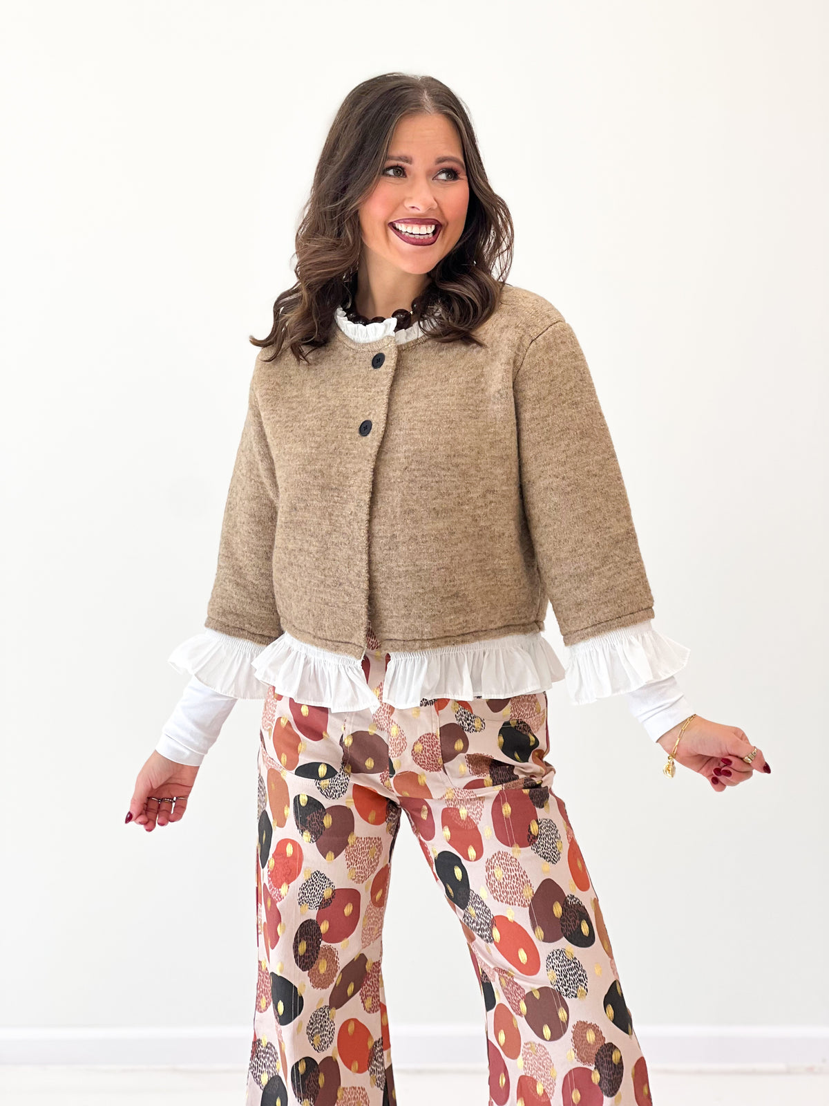 Mocha knit cardigan with button placket and white ruffle trim at cuffs and hem