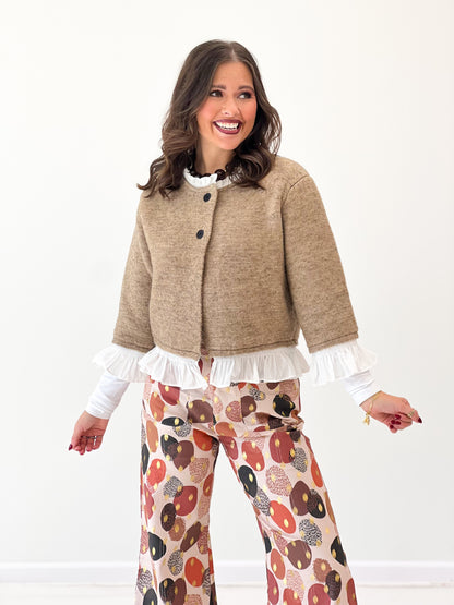 Mocha knit cardigan with button placket and white ruffle trim at cuffs and hem