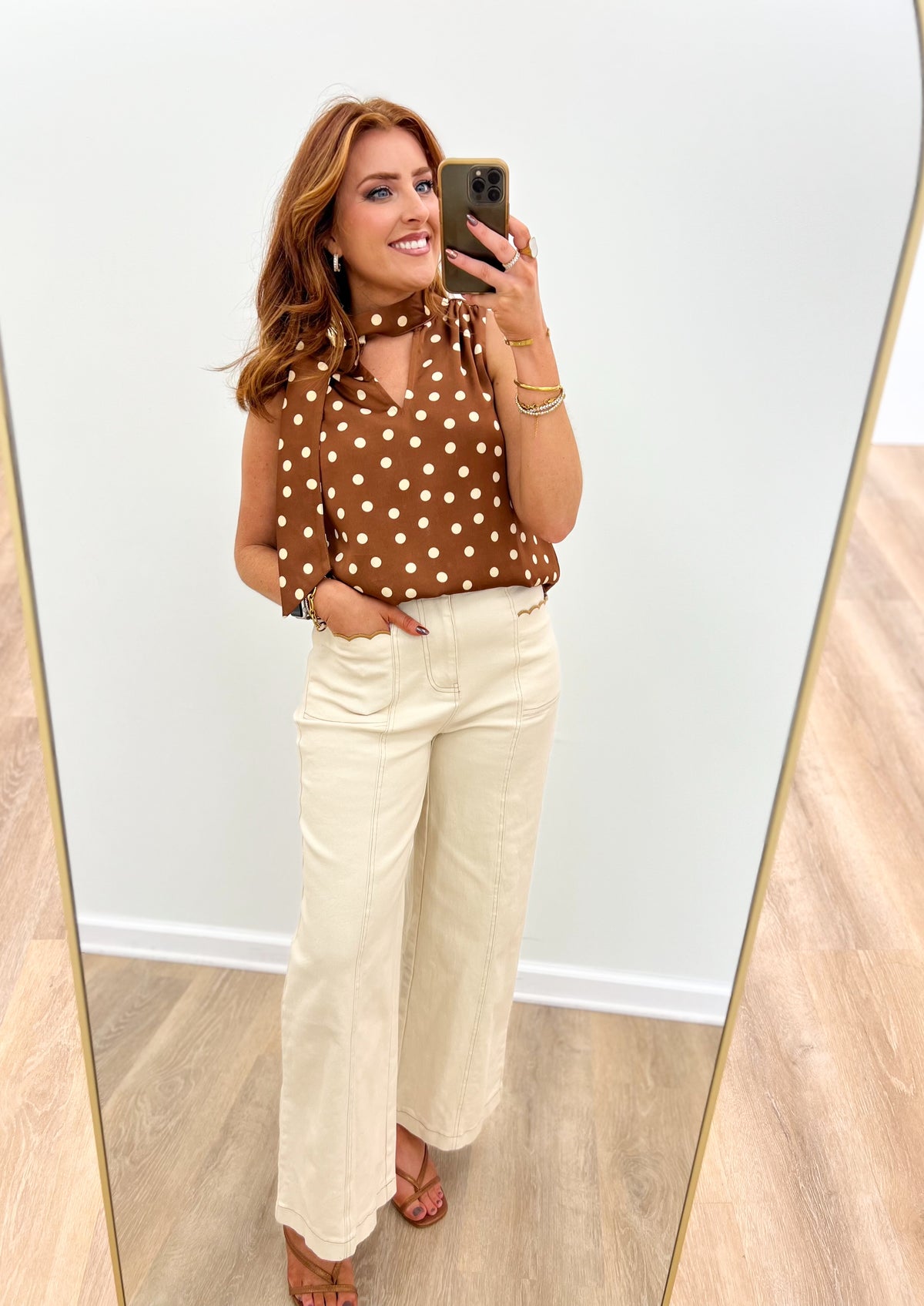 Brown polka dot sleeveless top with buttoned high neckline detail