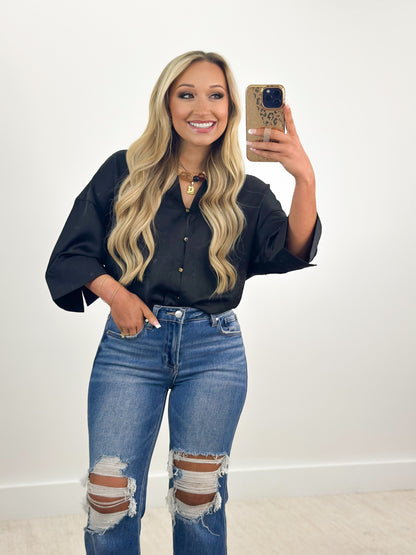 Black V-neck button-down shirt with metal buttons and collar detail