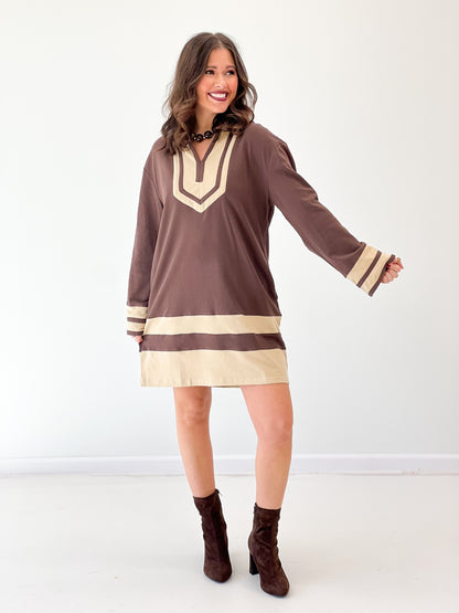 Brown V-neck sweatshirt dress with cream collar trim and horizontal hem stripe
