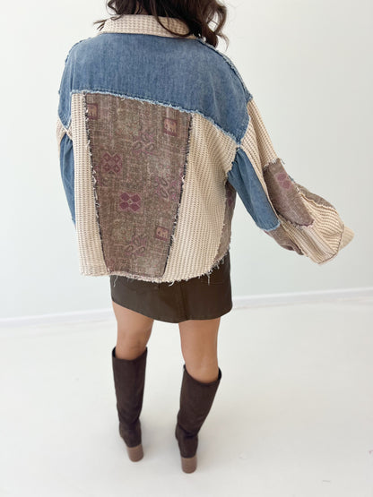 Back of patchwork shacket with large square panel, denim yoke, and frayed edges