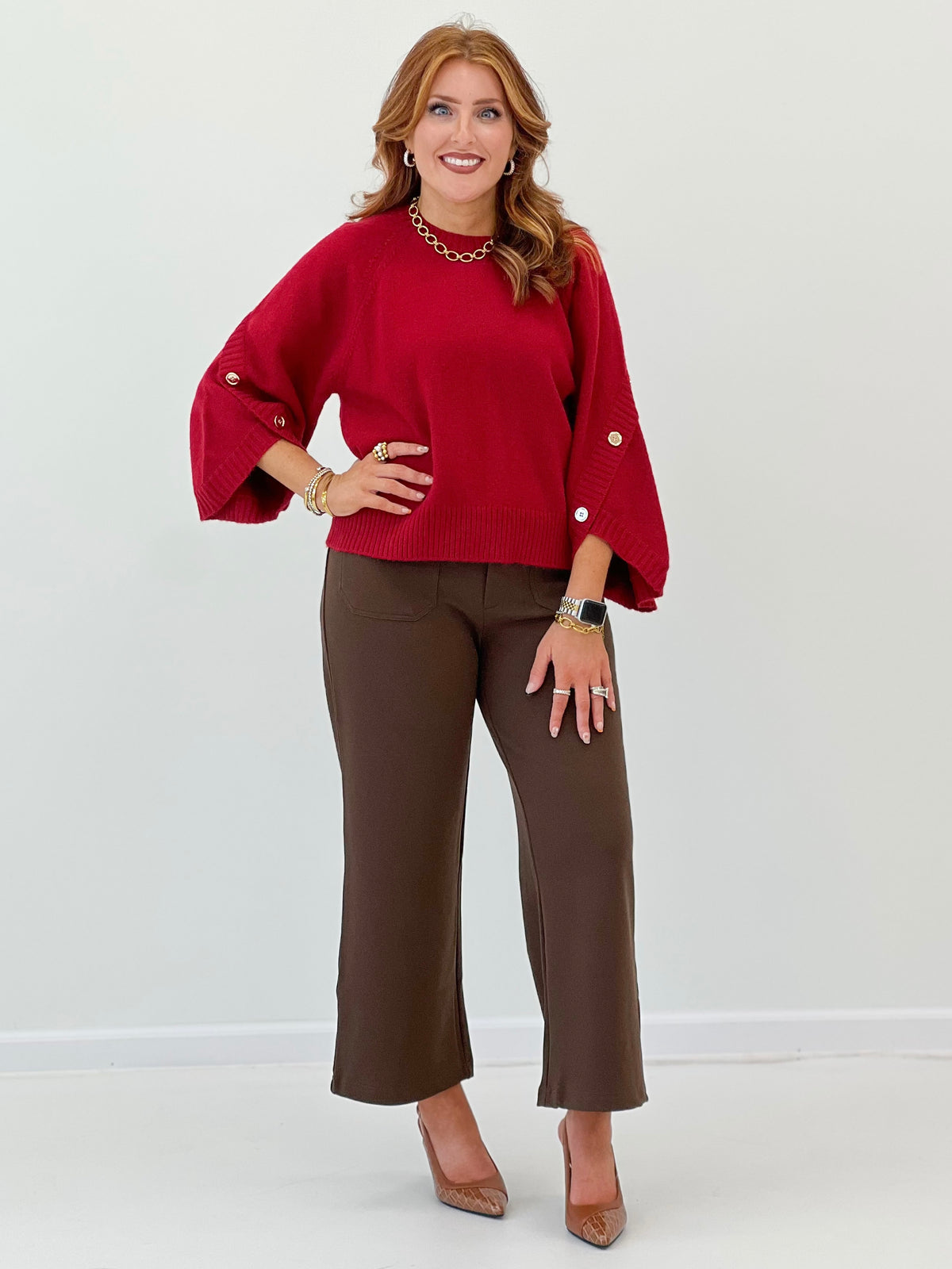 Women's red knit sweater with poncho sleeves and cuff buttons, relaxed fit