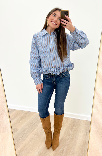 Women's blue striped button-front top with long sleeves and ruffle hem