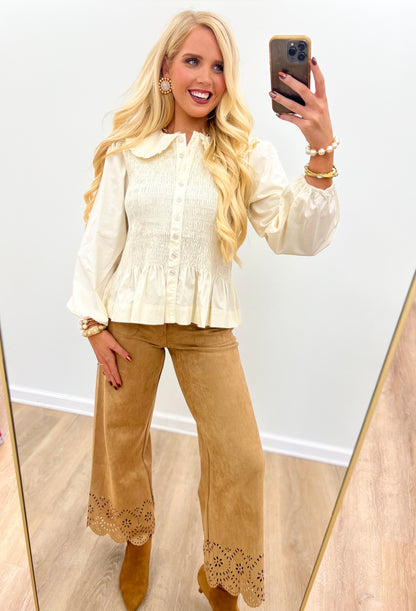 Cream smocked peplum blouse with Peter Pan collar, button front, long sleeves