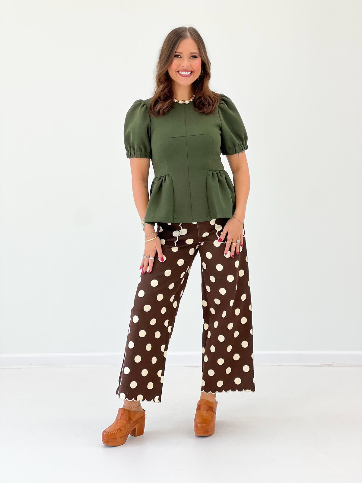 Olive green peplum hem knit top with short puff sleeves and crew neck