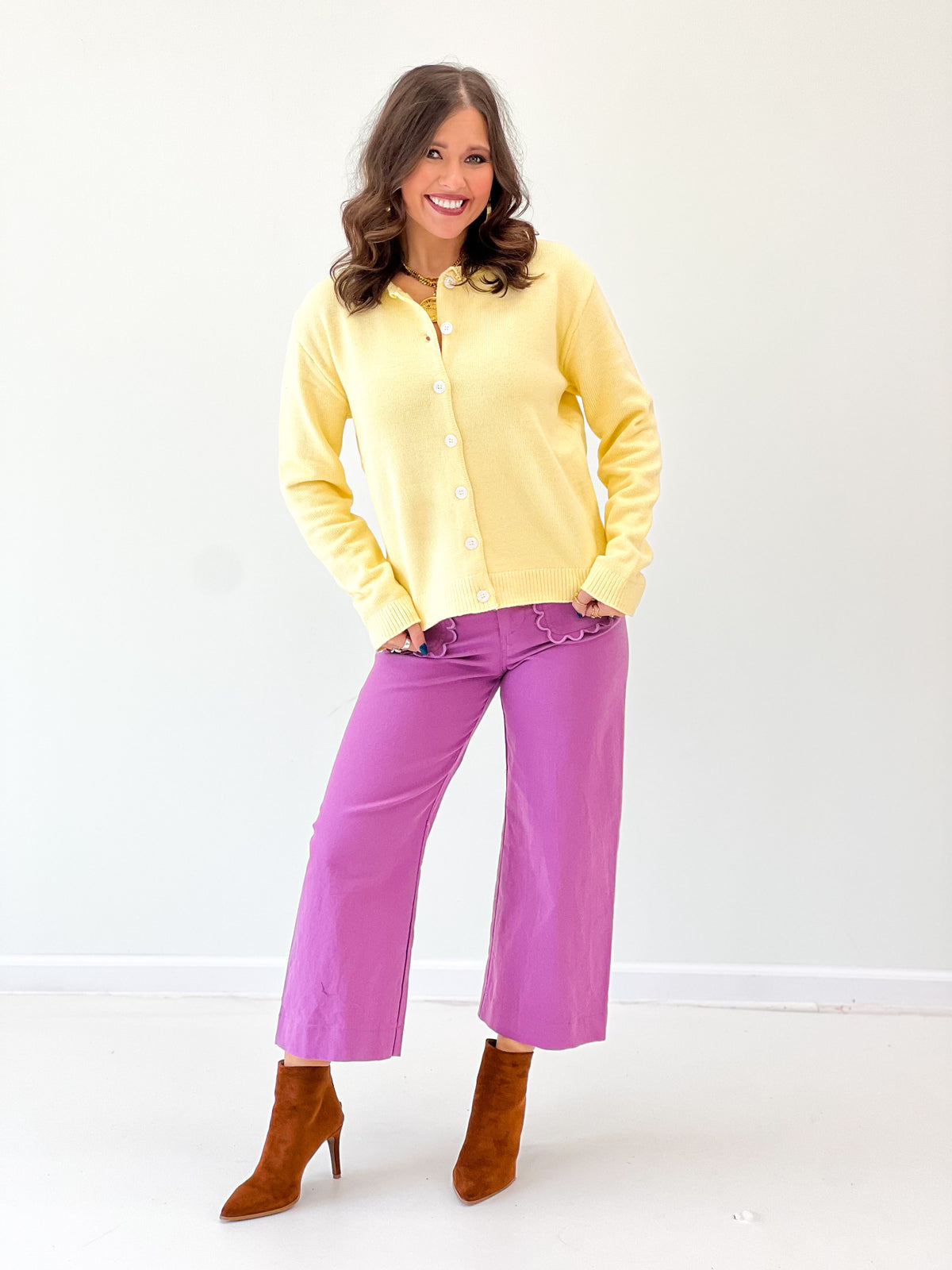 Yellow button-up cardigan with round neckline and front button closure, long sleeves