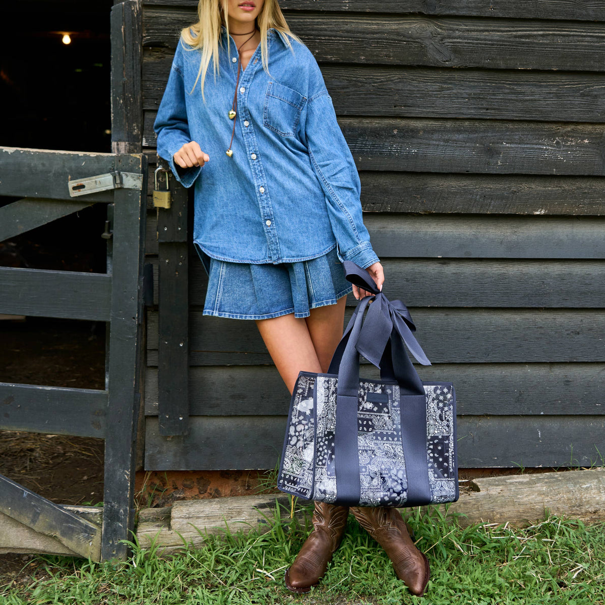 Patterned navy jelly tote bag with oversized bow closure and dual top handles.