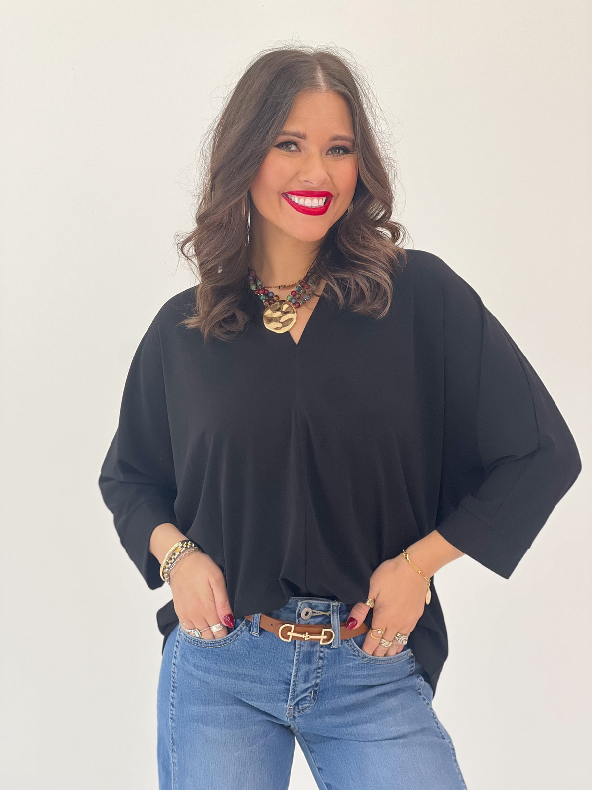 V-neck quarter-sleeve top in black with loose silhouette and wide neckline