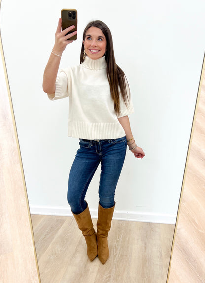 Off-white short-sleeve knit turtleneck sweater with ribbed hem and cuffs