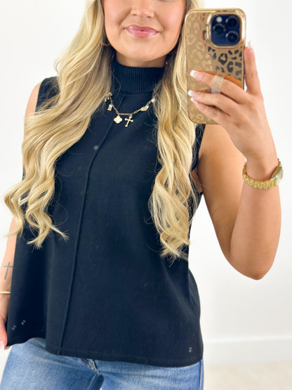 Navy sleeveless turtleneck knit top with fitted bodice and high neckline