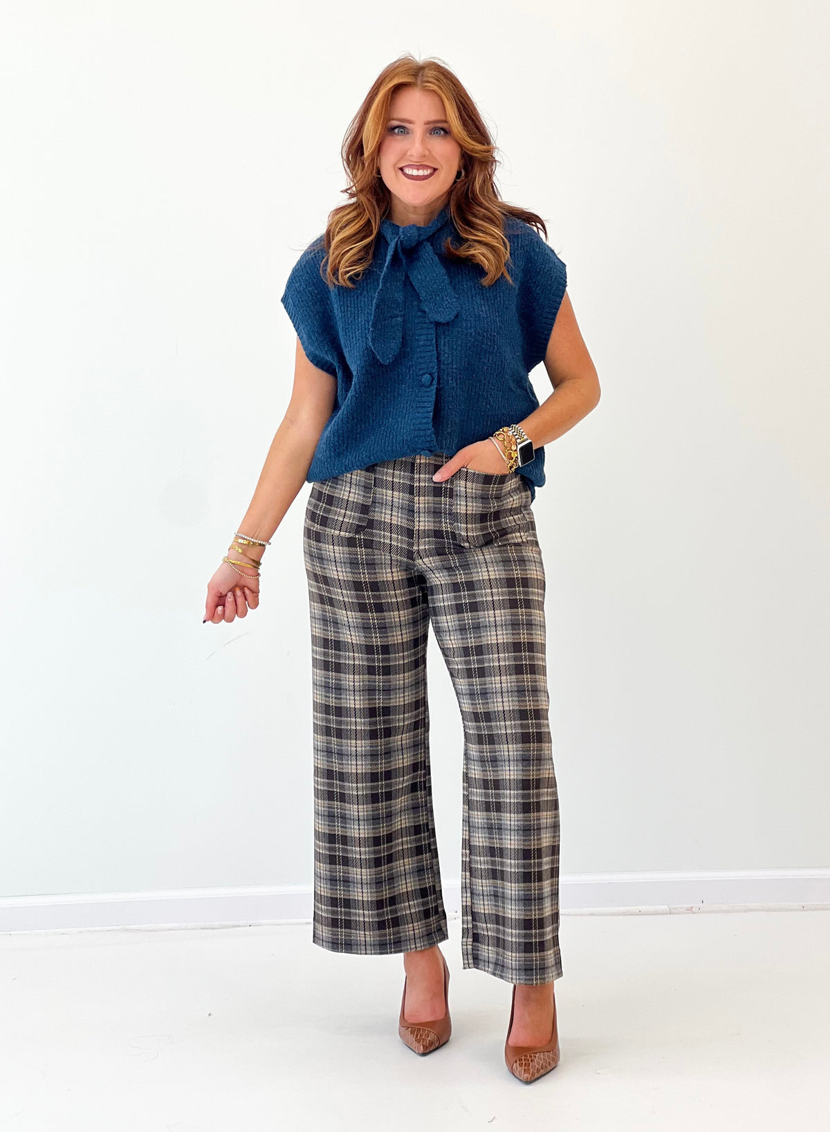 Teal knit sweater vest with button front and bow tie neckline, short sleeves