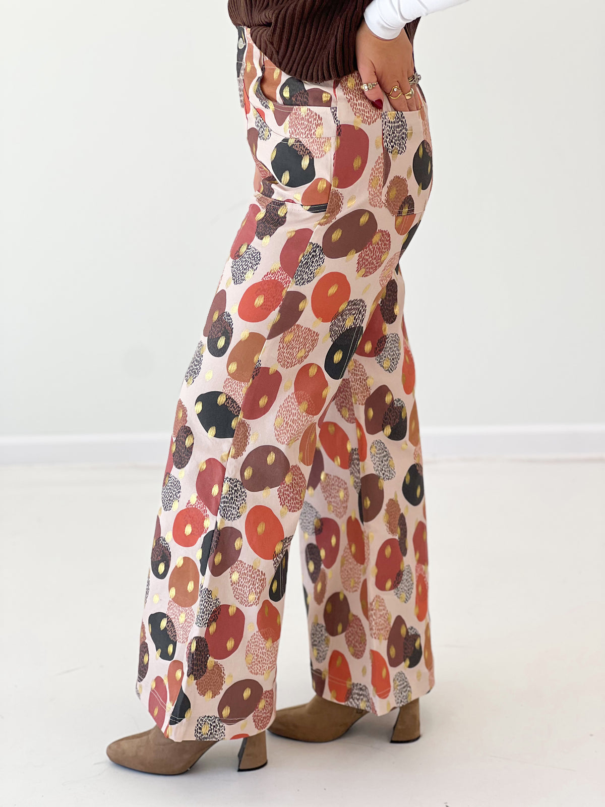 Wide-leg pants close-up with multicolor abstract foil print and flared cuffs