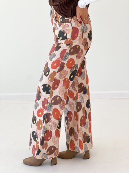 Wide-leg pants close-up with multicolor abstract foil print and flared cuffs