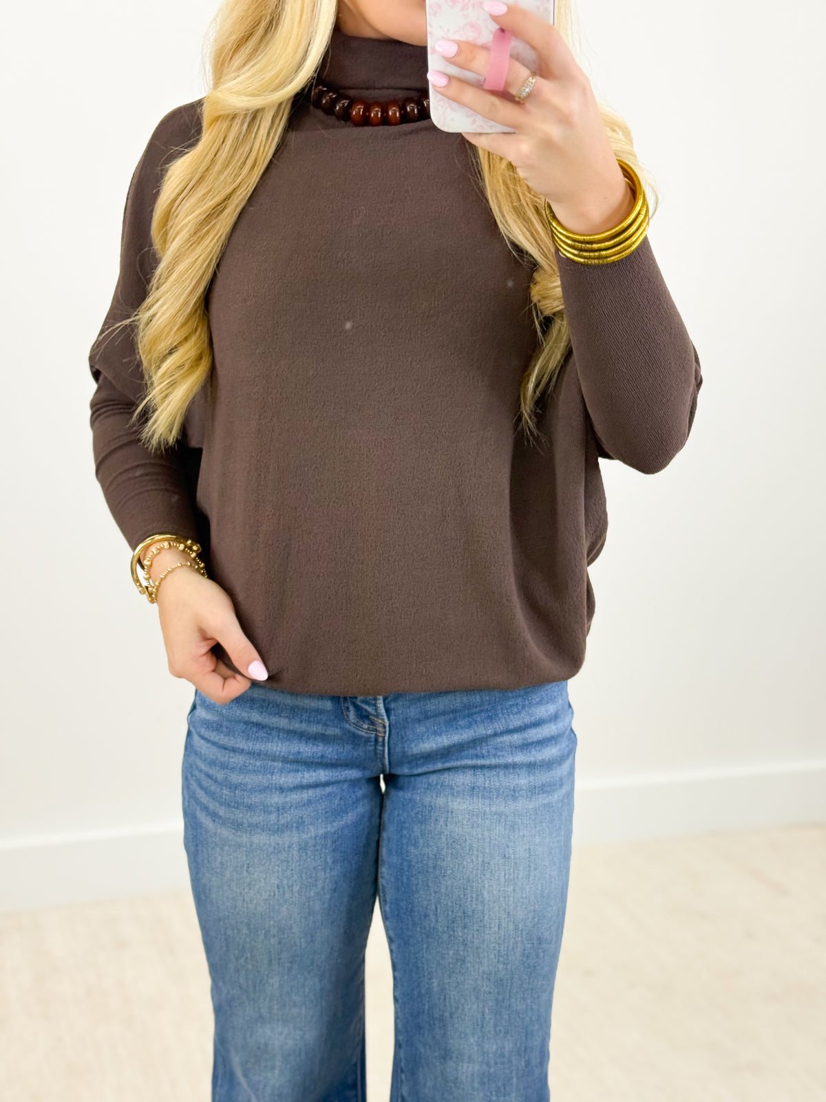 Dark brown mockneck dolman top with long sleeves and relaxed draped fit