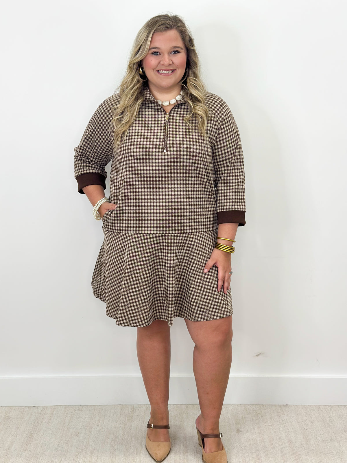 Brown gingham half-zip mini dress with long sleeves and flared skirt