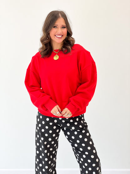 Red off-shoulder sweatshirt with wide neckline and gathered cuffs