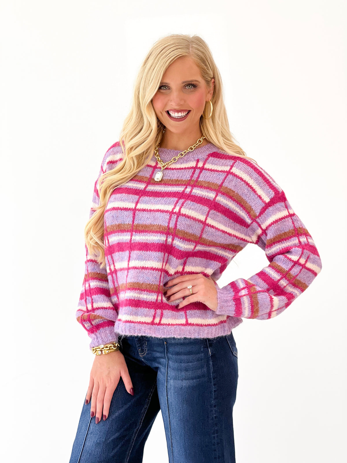 Pink plaid crew neck sweater with striped knit and long sleeves