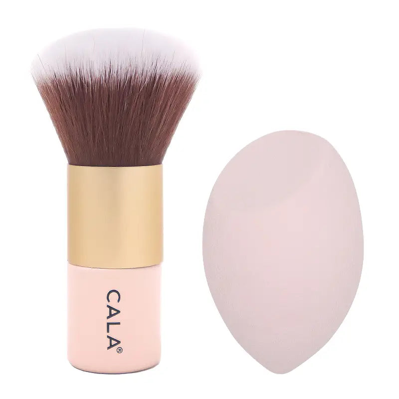 Pink-handled kabuki brush with gold ferrule and a pale pink blending sponge
