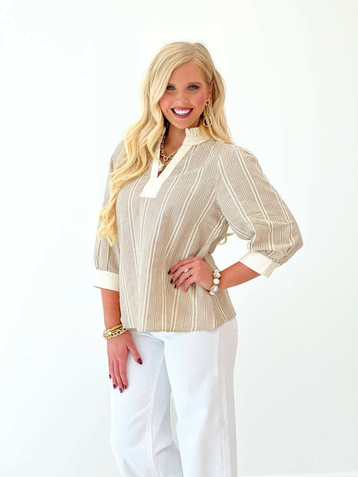 Taupe vertical striped top with white ruffle collar trim and elbow-length sleeves