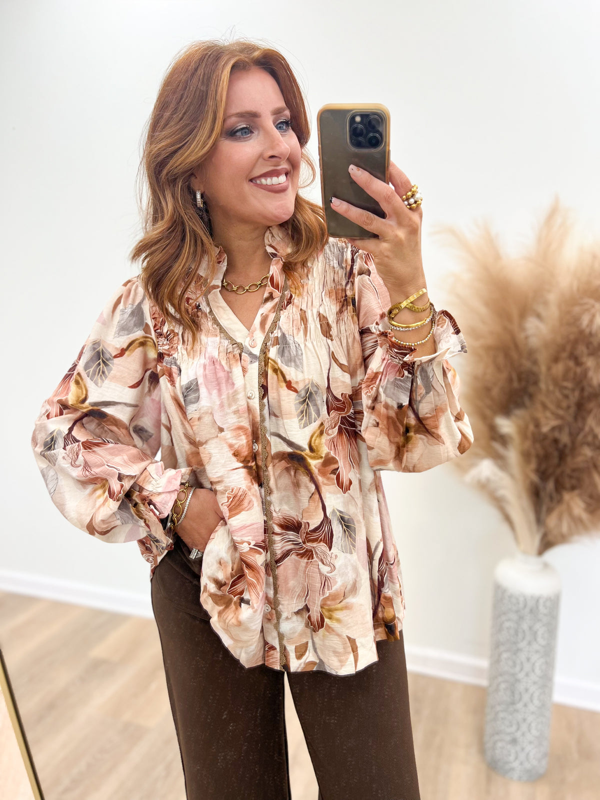 Brown floral print blouse with smocked yoke, button-front V-neck, and long puff sleeves