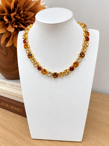 Gold-tone gemstone necklace with amber, red, and clear round beads