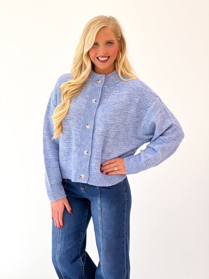 Denim blue marled knit cardigan with button-front placket and ribbed cuffs and collar.