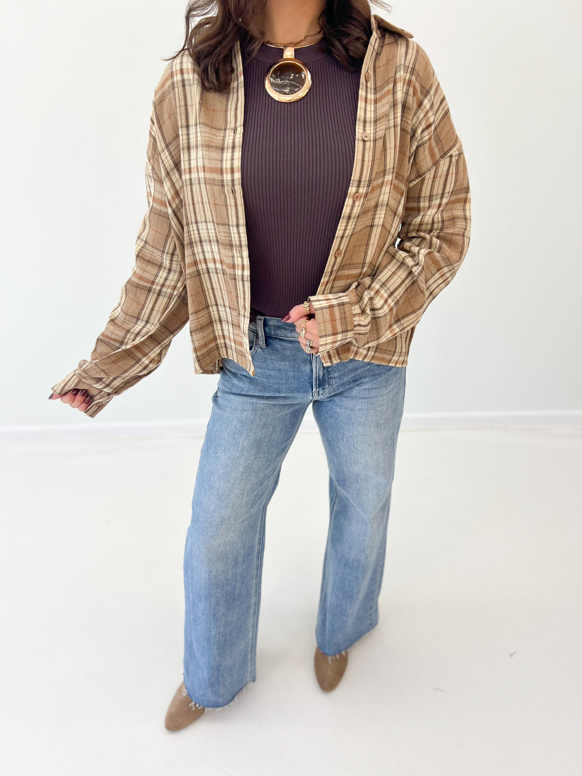 Mocha plaid button-up shirt hem and sleeves, button placket visible
