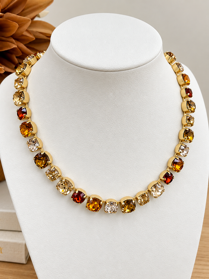 Gold-tone gemstone necklace with alternating amber, red, and clear round stones