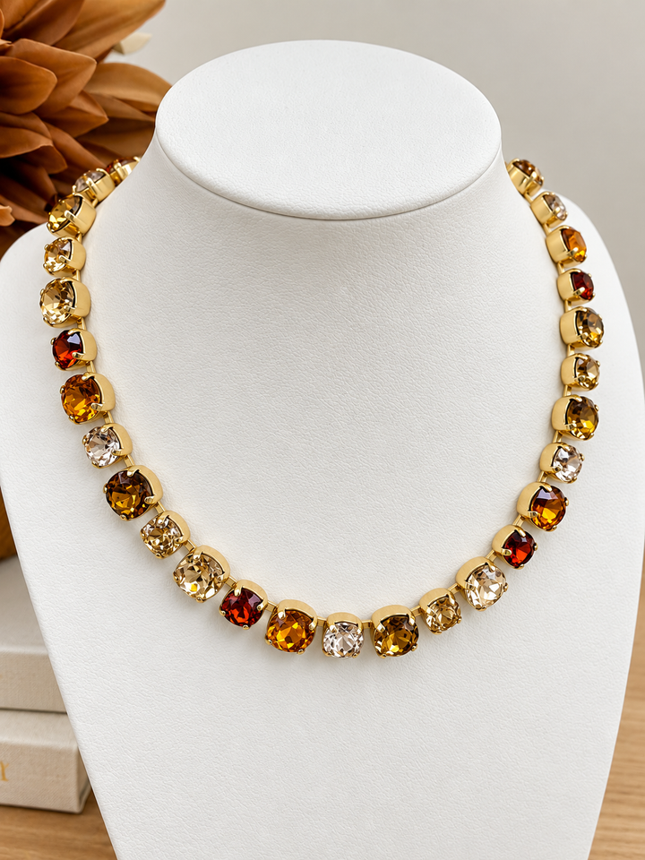 Gold-tone gemstone necklace with alternating amber, red, and clear round stones