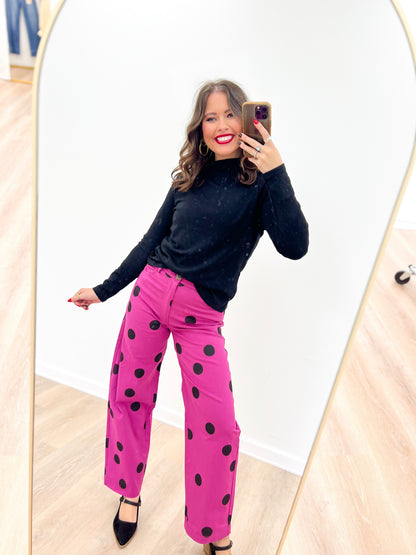 Magenta wide-leg stretch pants with large black polka dots and cuffed hem