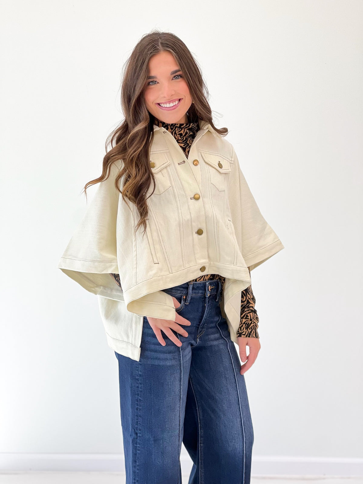 Ecru cropped denim jacket with short sleeves, snap buttons, and chest flap pockets