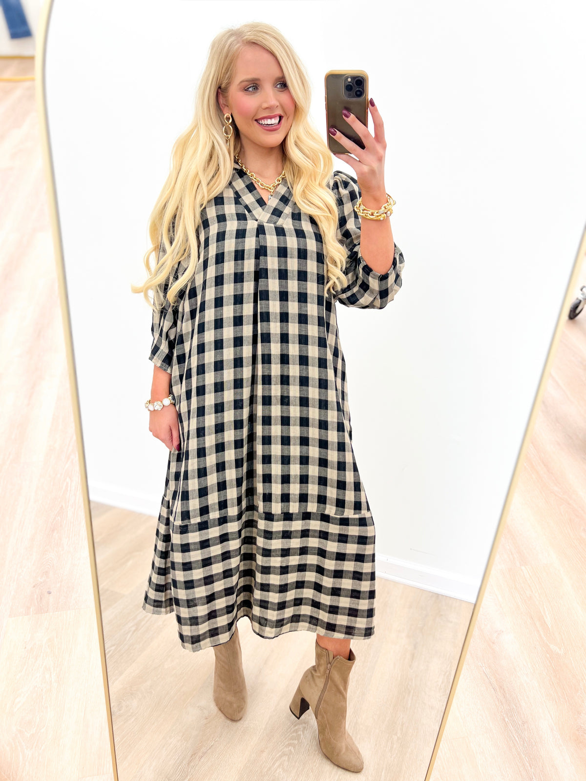 Black-and-white checkered midi dress with open collar and long, billowy sleeves