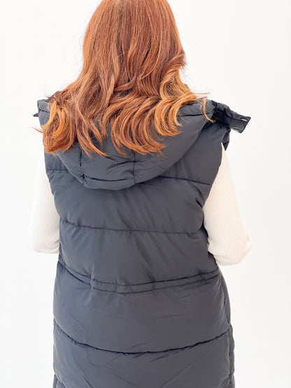 Back view of longline quilted puffer vest with hooded collar and horizontal quilting