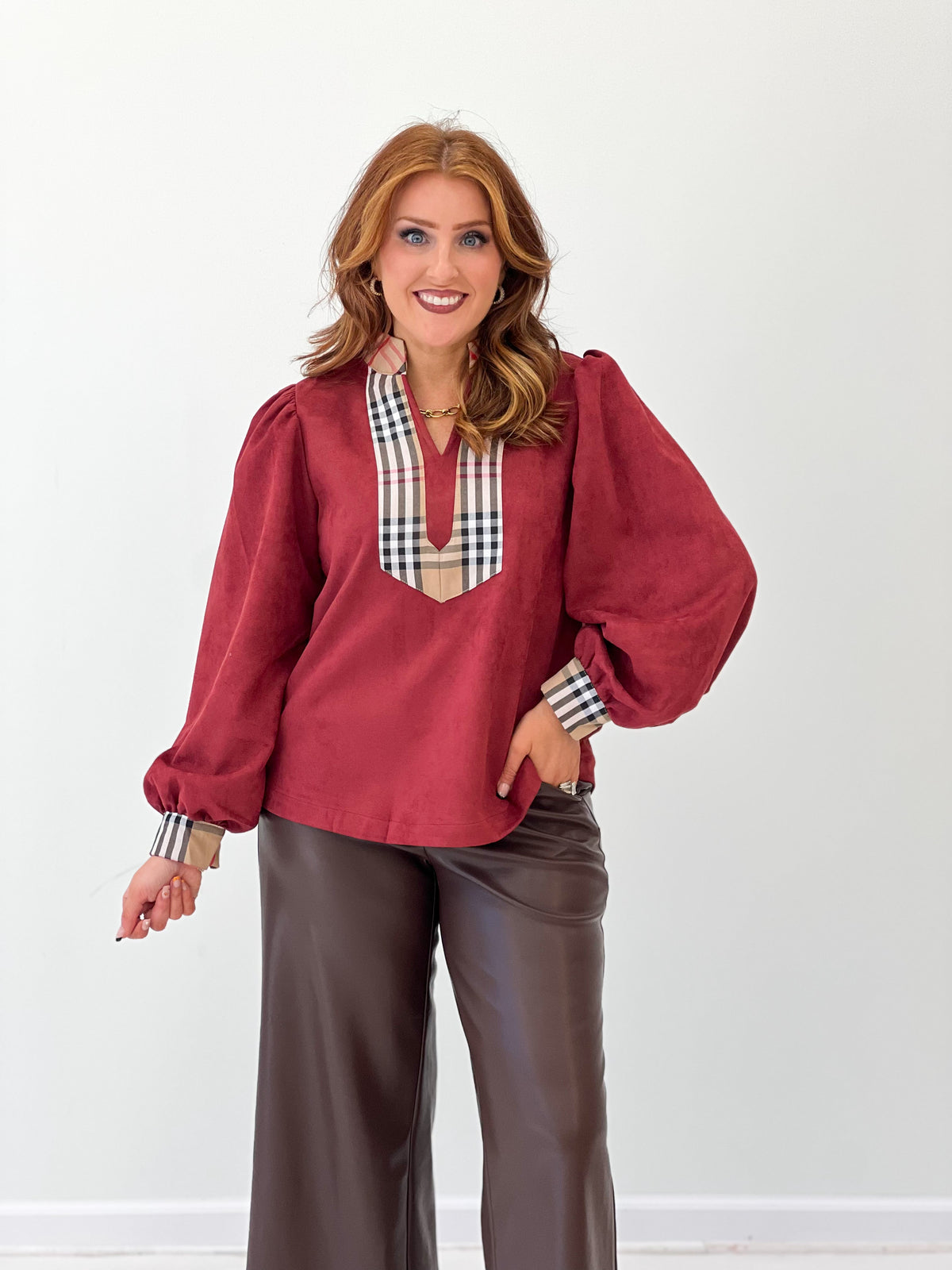 Burgundy faux suede puff-sleeve top with plaid V yoke and relaxed fit