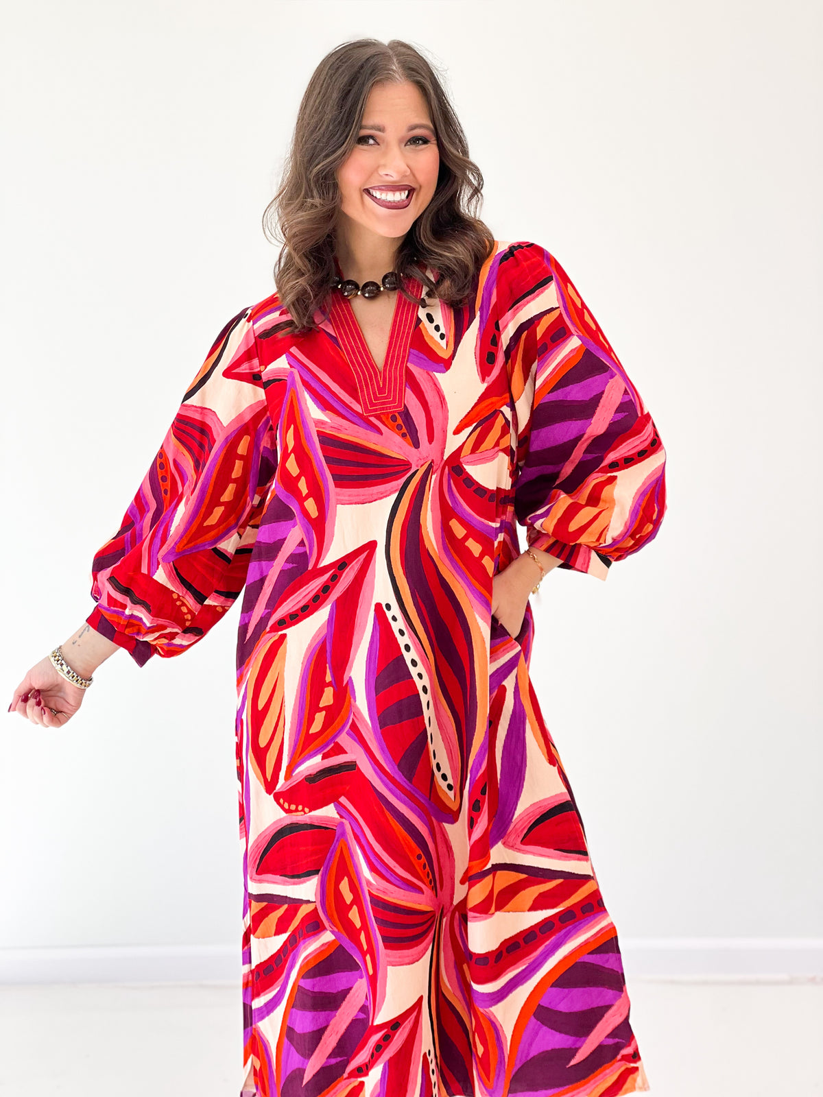 Red boho midi dress close view, V-neck and voluminous puff sleeves, abstract print