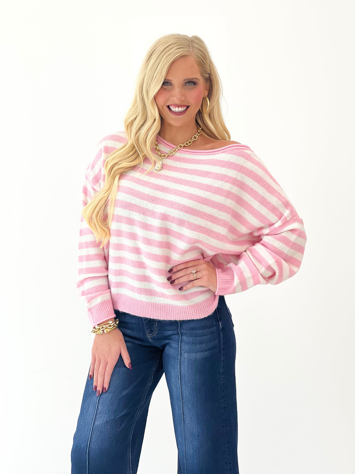 Pink and white striped off-shoulder sweater with long sleeves, ribbed cuffs