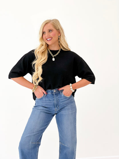 Heathered black crew neck sweater with soft knit texture and short sleeves