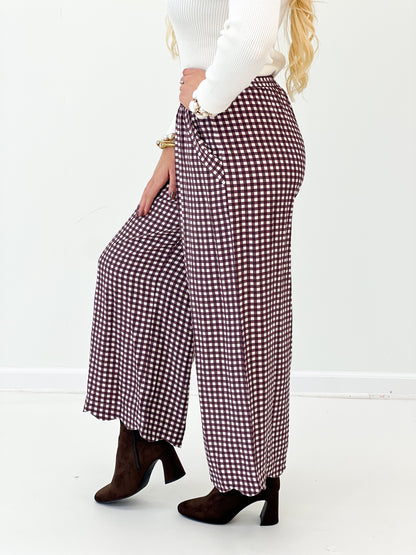 Red checkered wide-leg pants side view with flowing fabric and smocked waist