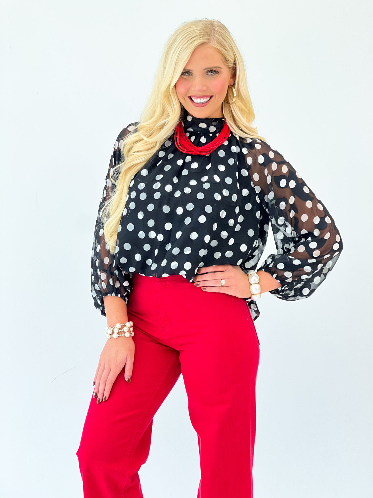 Black polka dot sheer long-sleeve blouse with red high-neck collar