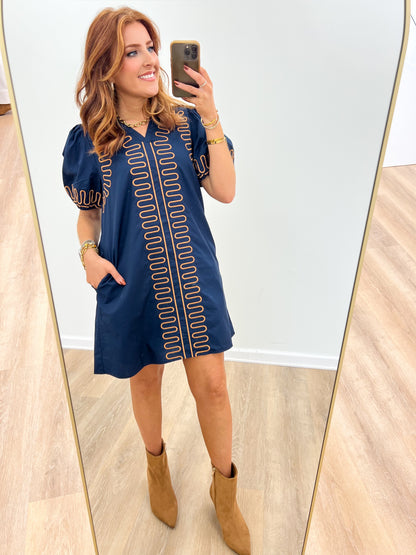 Navy short-sleeve dress with vertical red embroidered trim and scalloped yoke detail