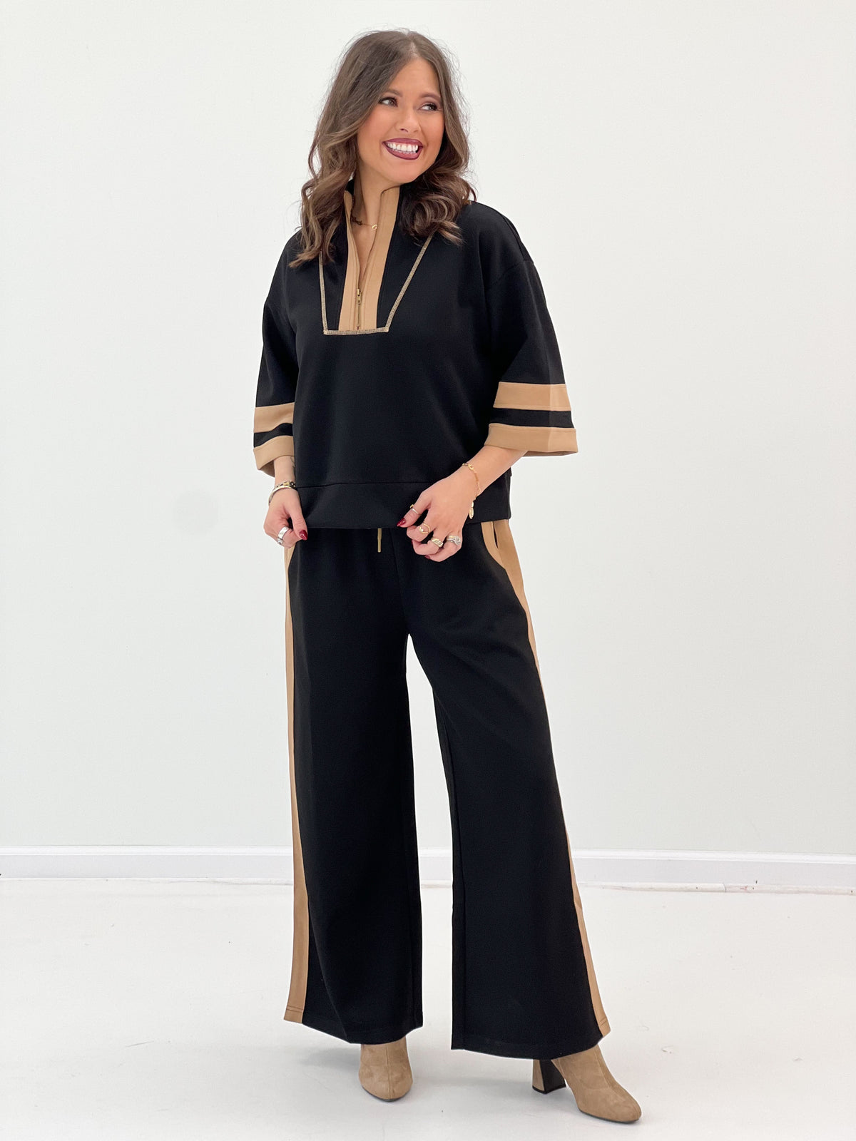 Black zip-up sweatshirt with tan trim and wide-leg pants, relaxed fit side split
