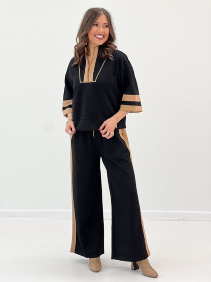 Black zip-up sweatshirt with tan trim and wide-leg pants, relaxed fit side split