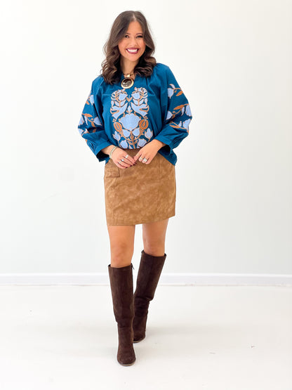 Camel vegan leather mini skirt with centered seams and straight fit